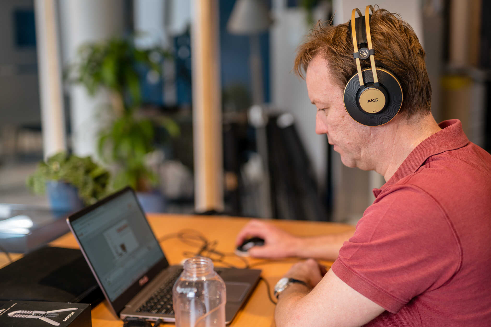 Man aan het werk achter laptop met koptelefoon op