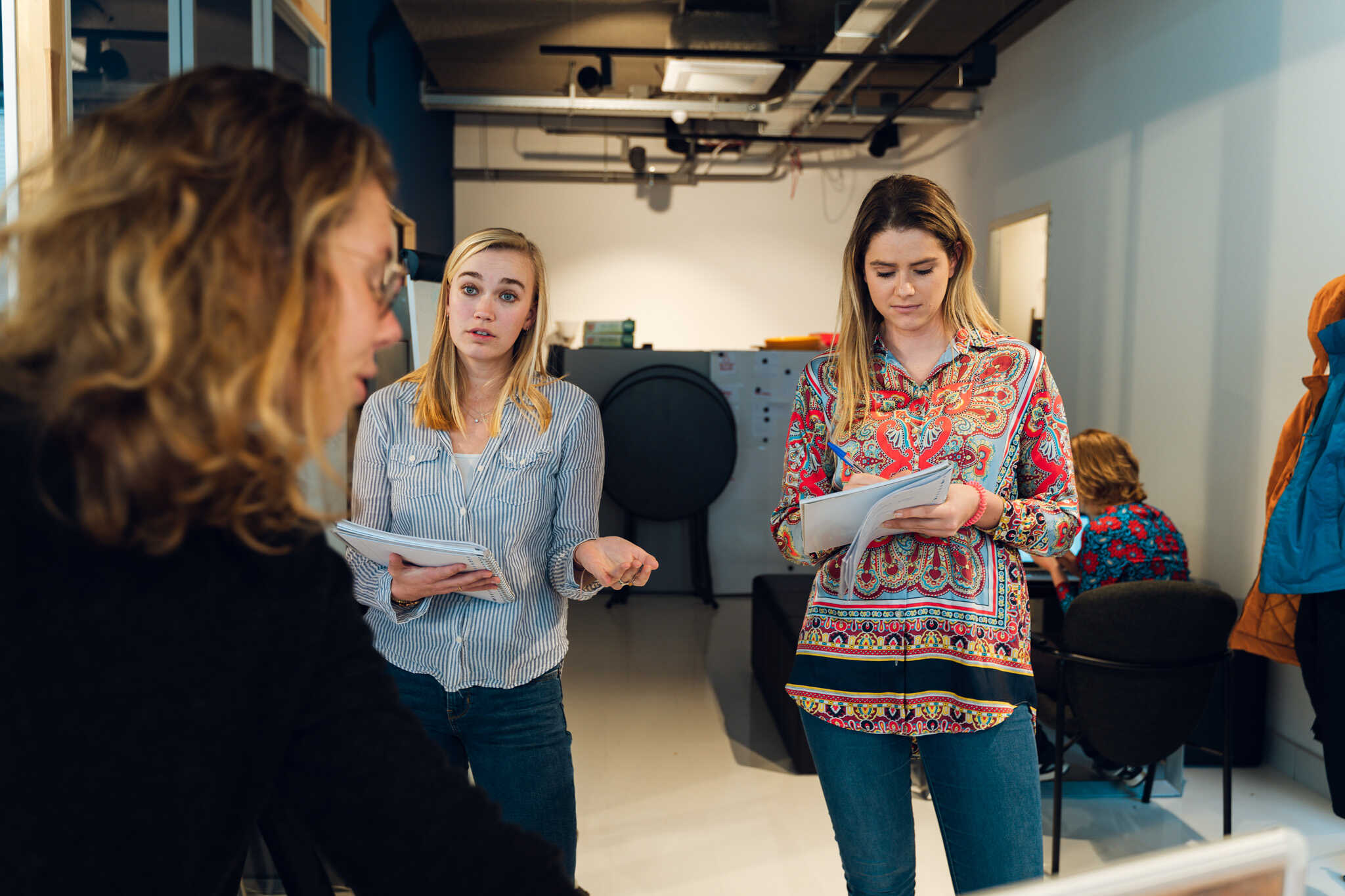 3 vrouwen die in gesprek zijn en notities maken