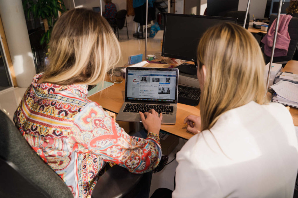 Twee vrouwen die op een laptop naar de Facebook van Ctalents kijken