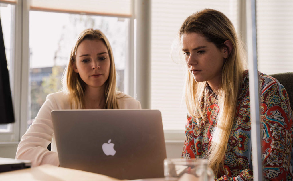 twee vrouwen achter een laptop aan het werk