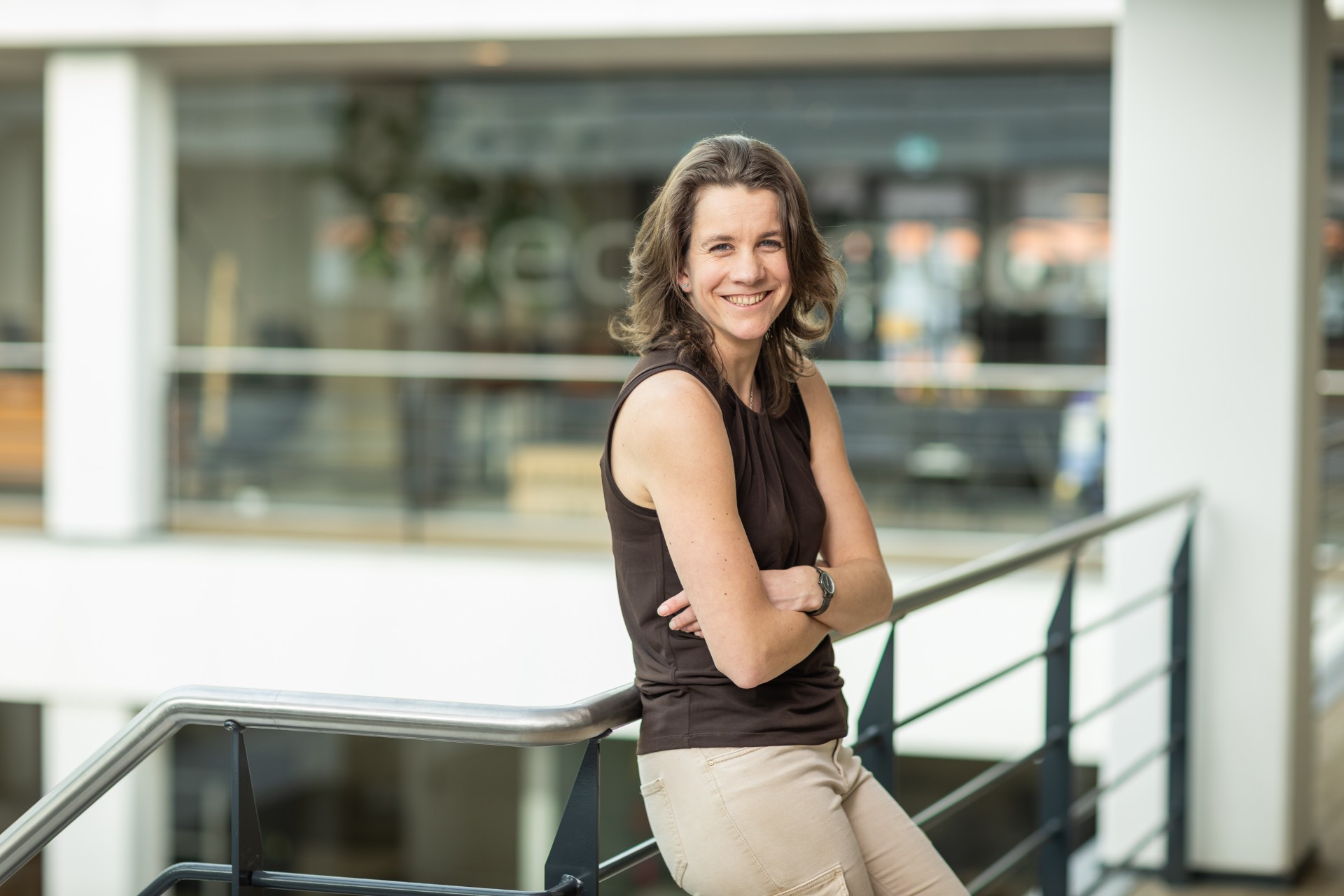 Foto van Sharon die haar armen over elkaar heeft en glimlacht